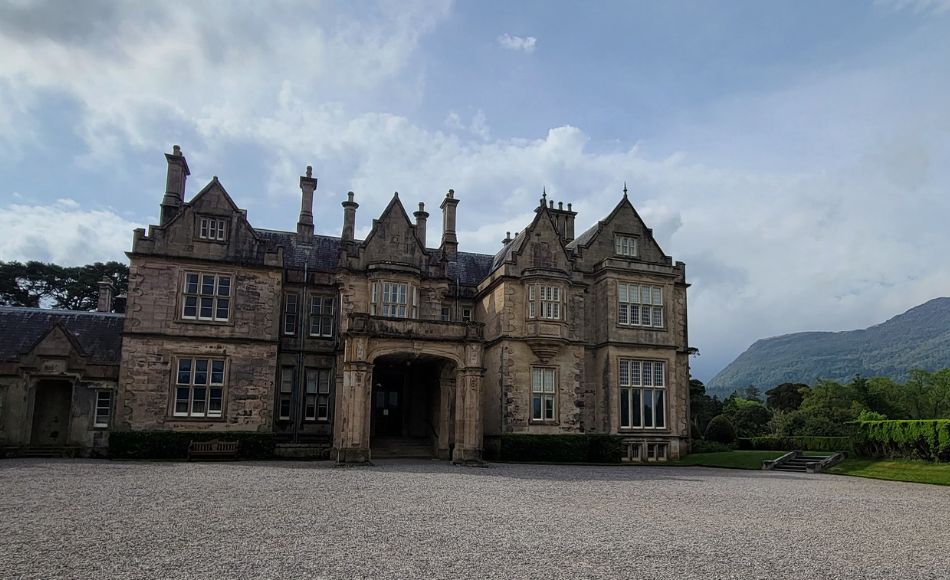 Outside view of Muckross House with the mountains of Killarney National Park in the background.